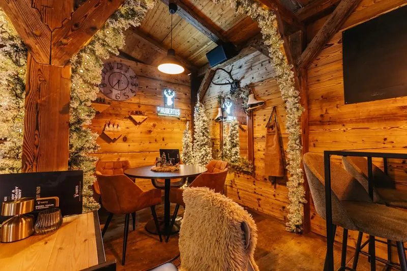 Het warme houten interieur van Chalet 9620 met lichtjes en kerstbomen